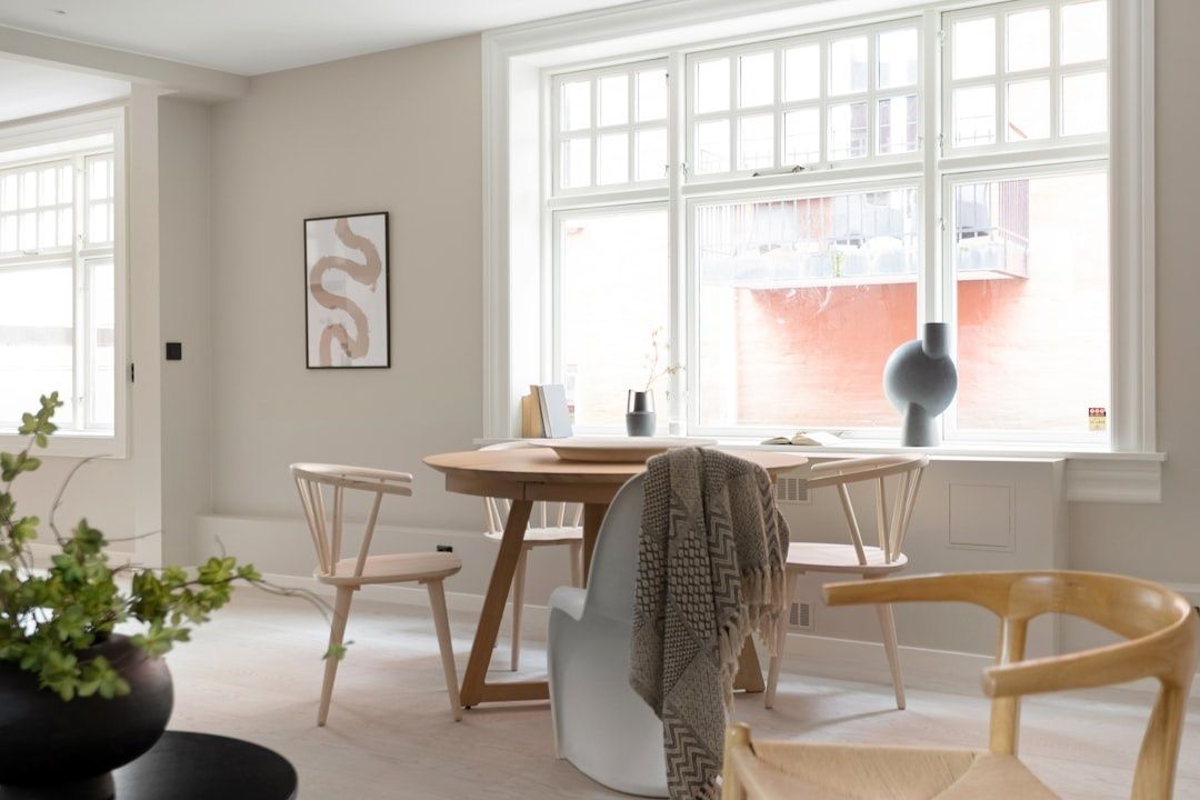 Ljust skandinaviskt matrum med träbord, stolar och neutral inredning